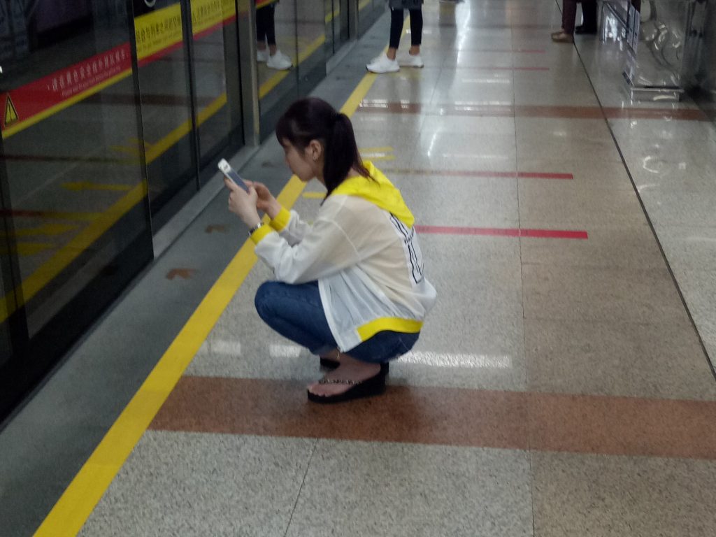 Chiense girl crouching at metro