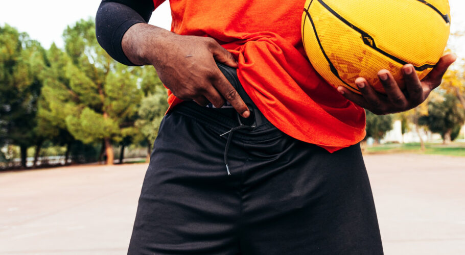 afro black guy showing his gun urban basketball court