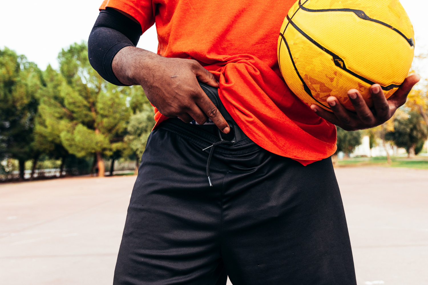 afro black guy showing his gun urban basketball court