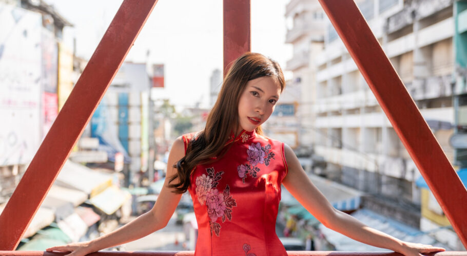 asian woman wearing red cheongsam qipao dress in chinatown for chinese new year looking seductive