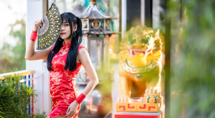 asian young woman wearing red traditional chinese cheongsam decoration holding chinese fanning chinese new year festival