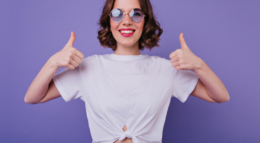 attractive european girl trendy sunglasses expressing positive emotions posing with thumbs up good humoured lady tamsen