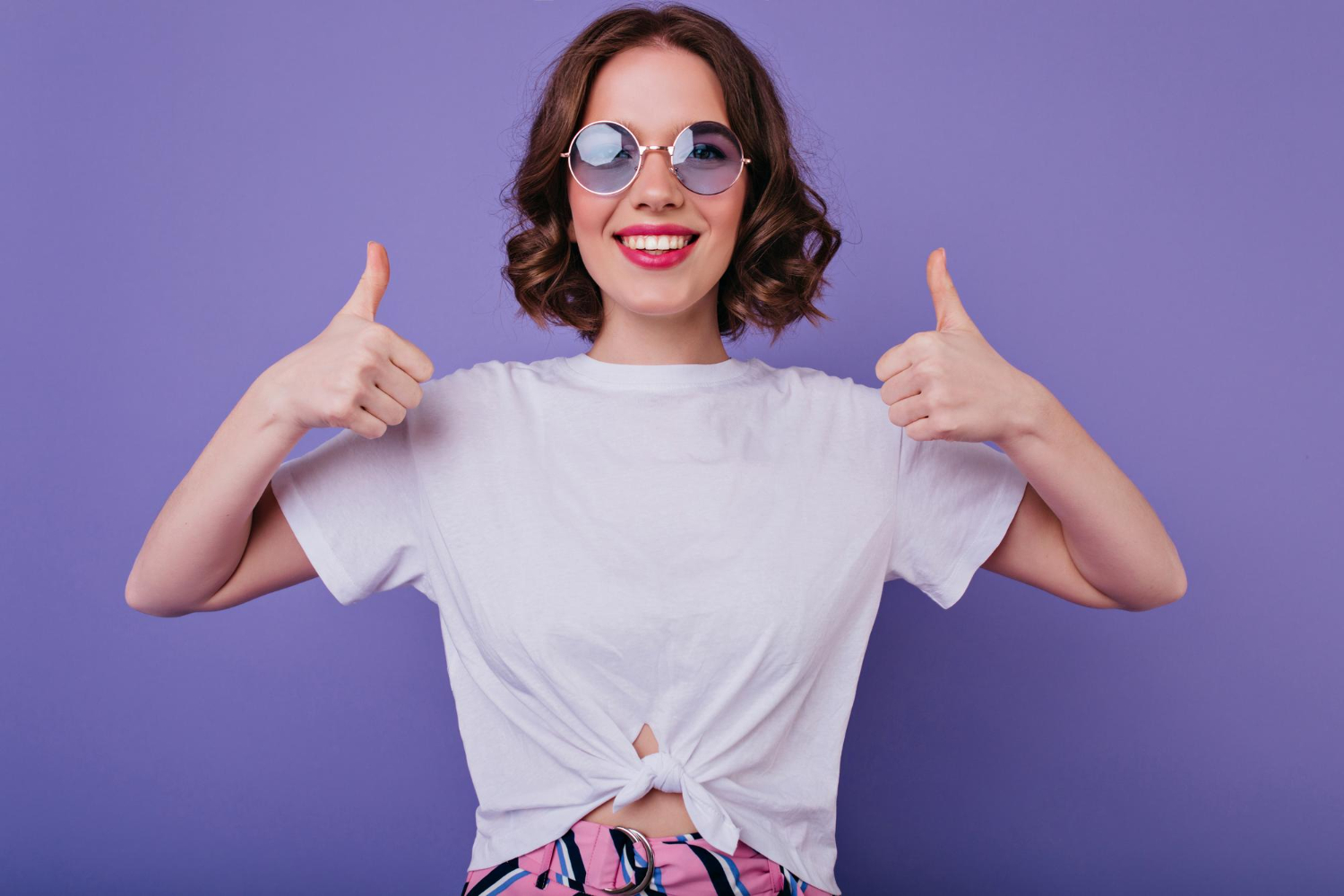 attractive european girl trendy sunglasses expressing positive emotions posing with thumbs up good humoured lady tamsen