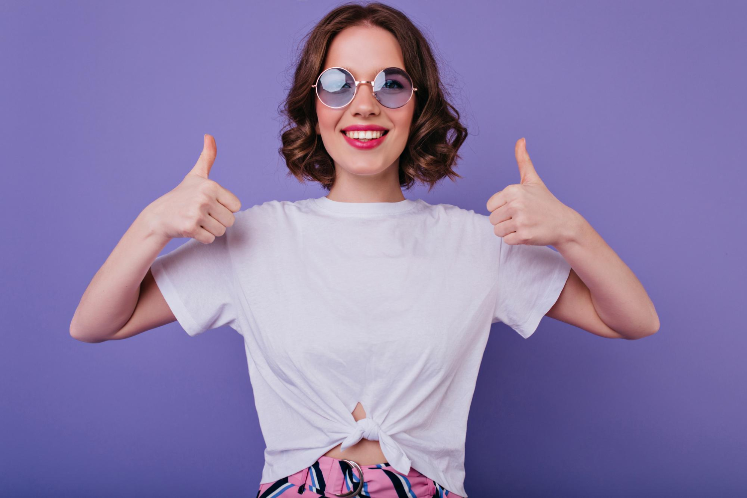 attractive european girl trendy sunglasses expressing positive emotions posing with thumbs up good humoured lady tamsen