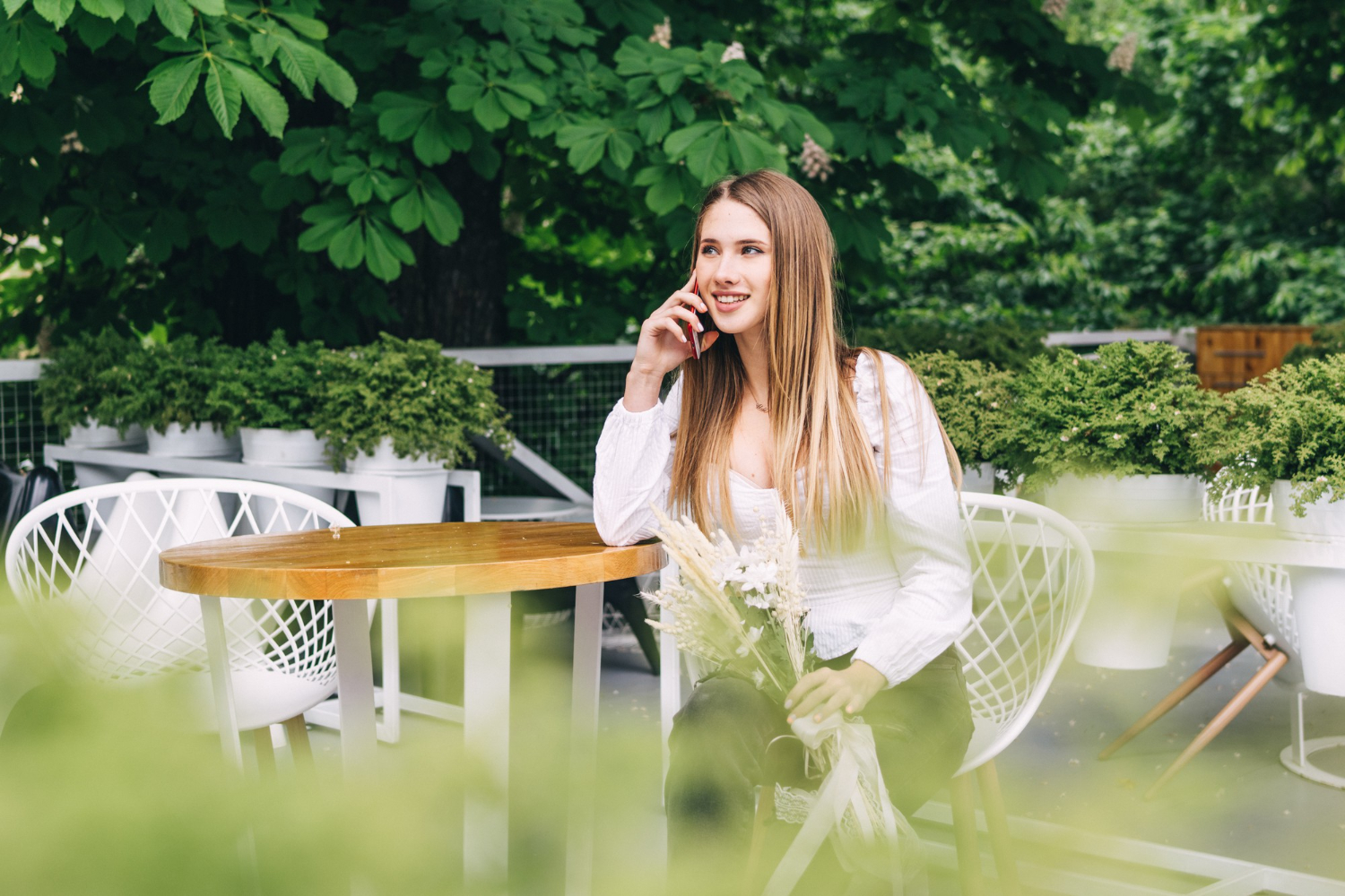 attractive woman sitting on a table madlyn speaking on phone