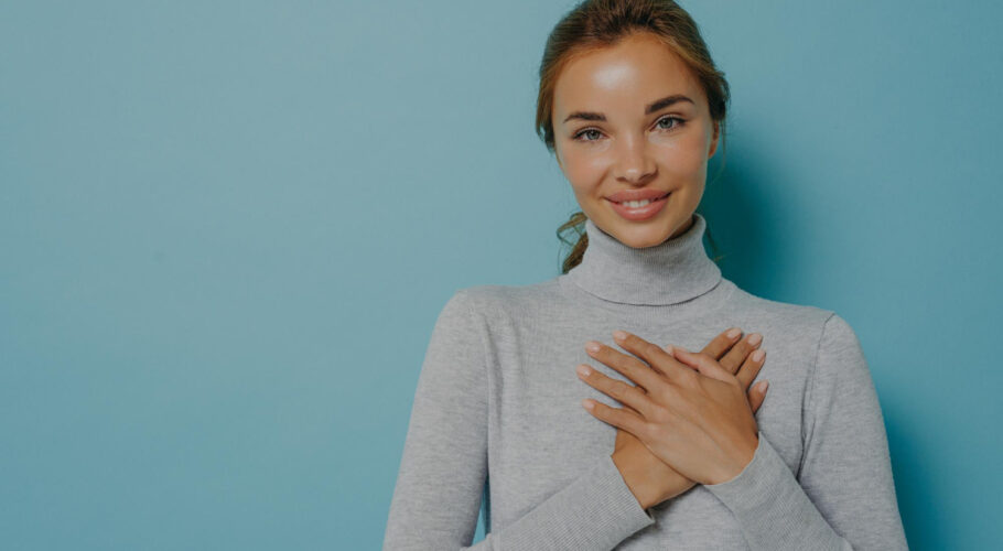 attractive young woman smiling holding hands near heart Valerie