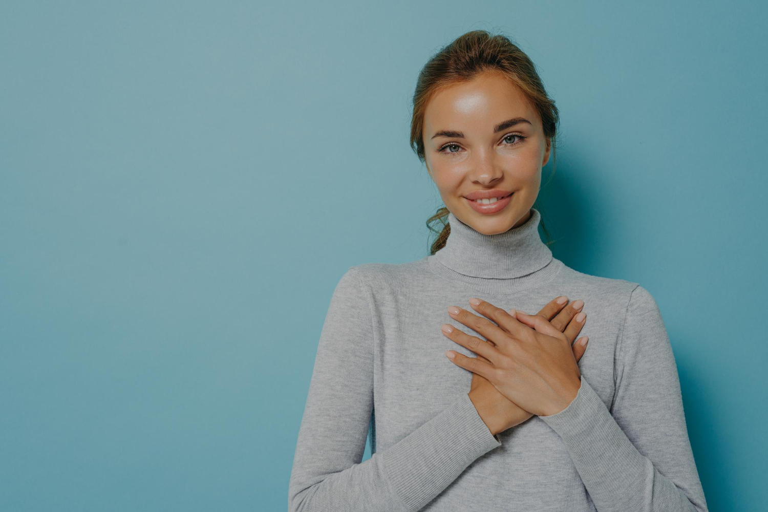 attractive young woman smiling holding hands near heart Valerie