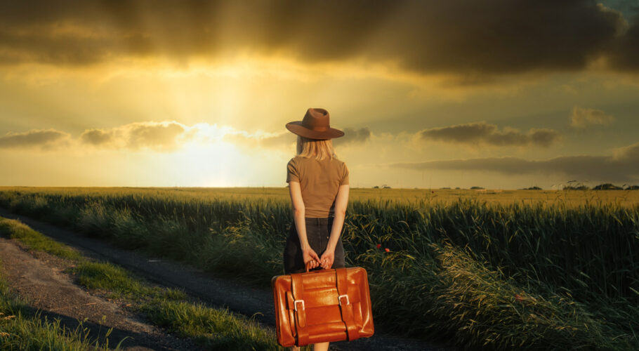 beautiful blonde girl with suitcase countryside road sunset time