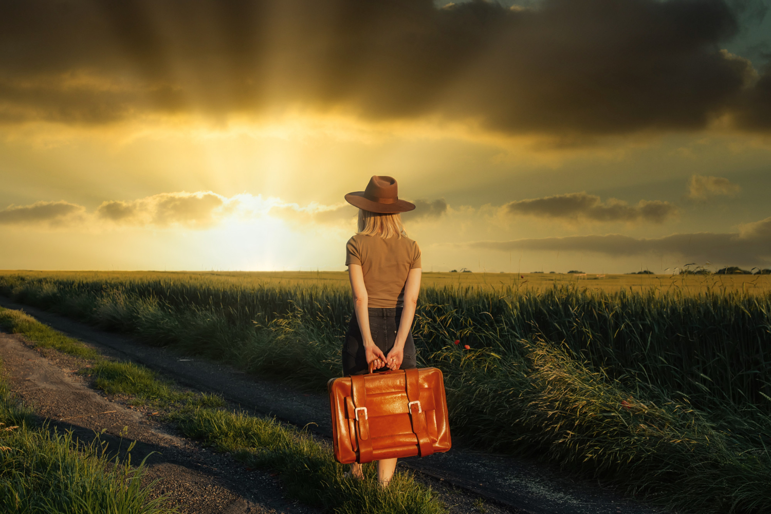 beautiful blonde girl with suitcase countryside road sunset time