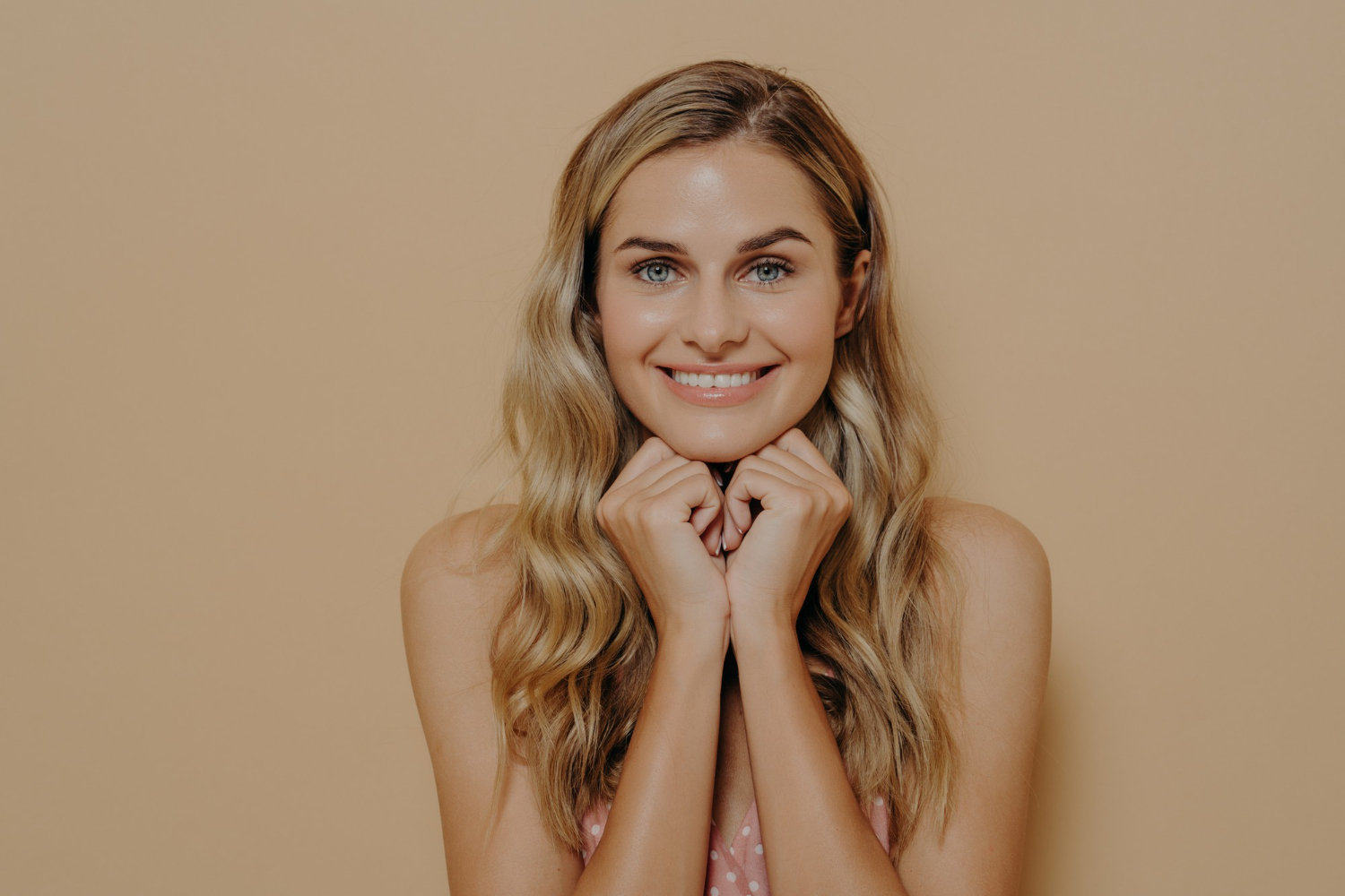 beautiful european female wearing summer light dress holding her hands on her chin