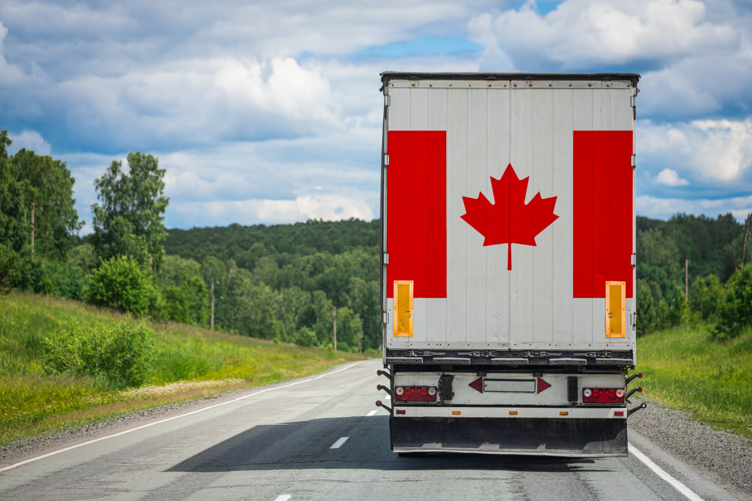 big cargo truck with national flag in canada moving on the highway