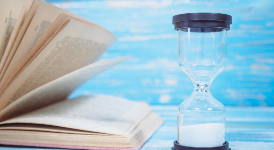 books hourglass blue wooden table time reflecting