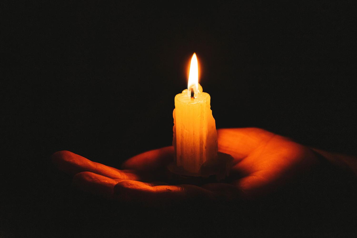 burning candle female hand dark background symbol life love light