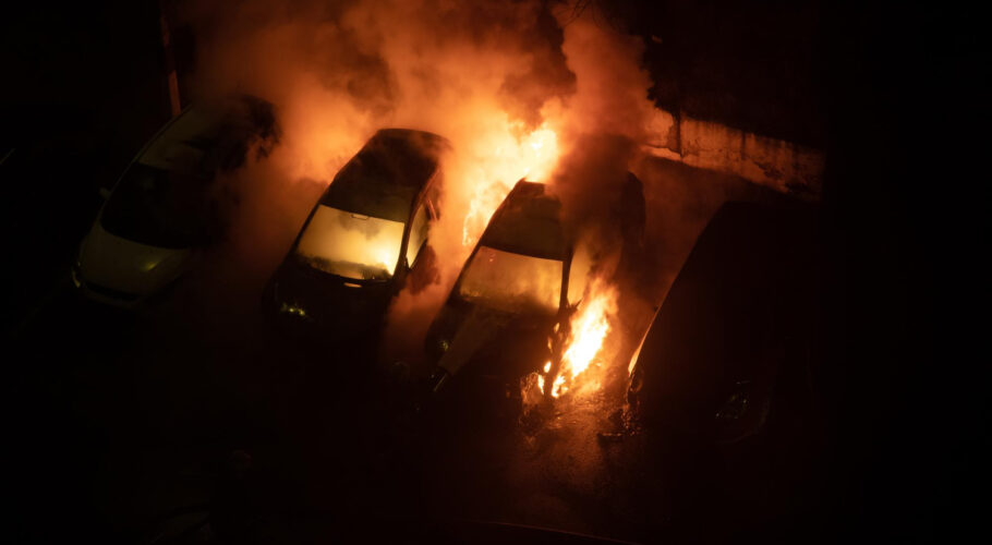 burning cars in parking lot at night