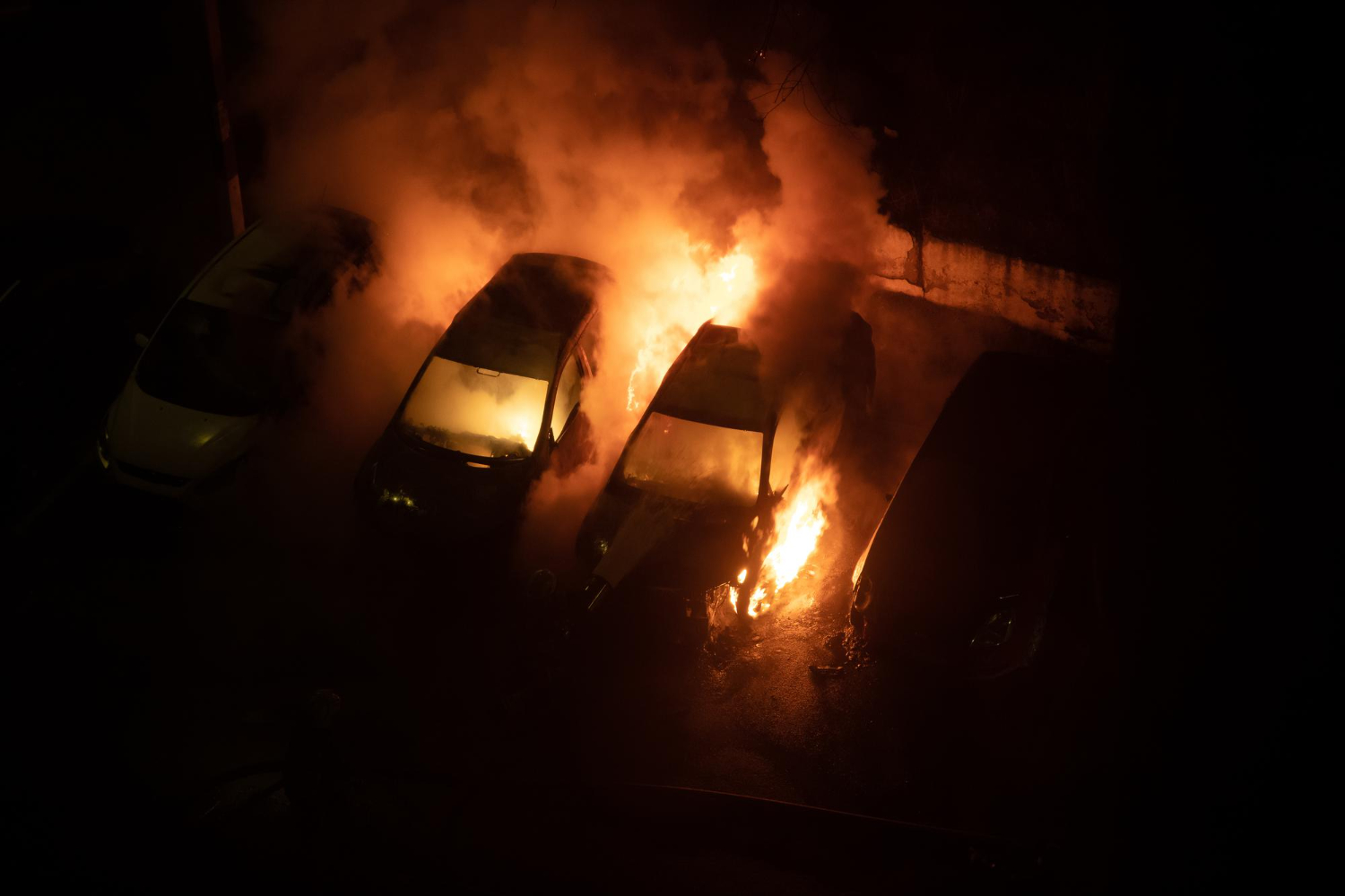 burning cars in parking lot at night