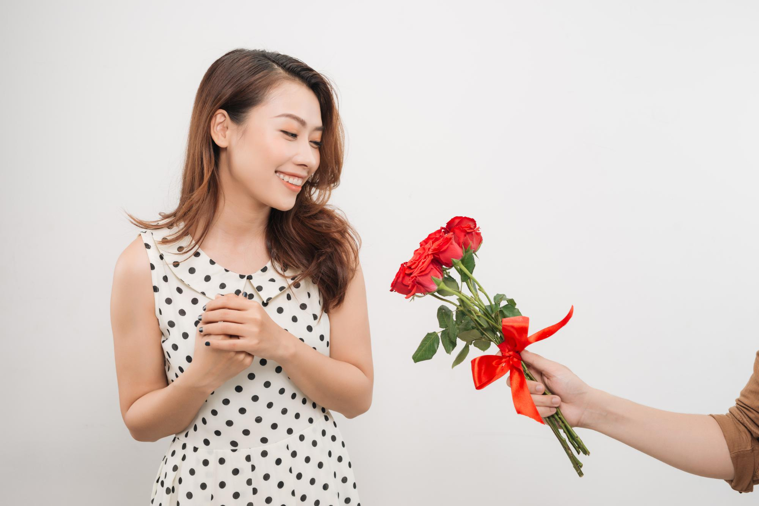 cheerful charming young woman receiving bunch flowers from her boyfriend