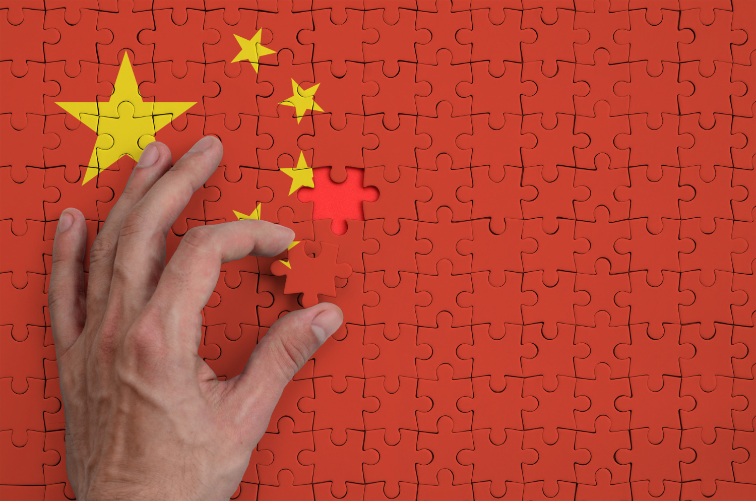 china flag is depicted puzzle which mans hand completes fold