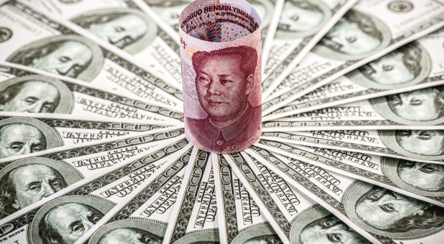 chinese money renminbi 100 yuan note cornered by many hundred dollar bills