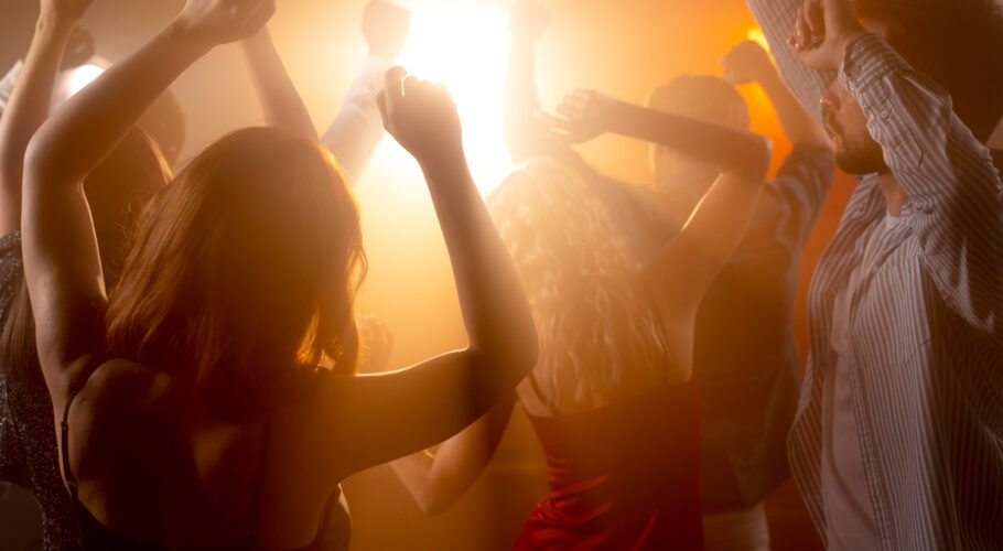 close up of people at nightclub having fun dancing together