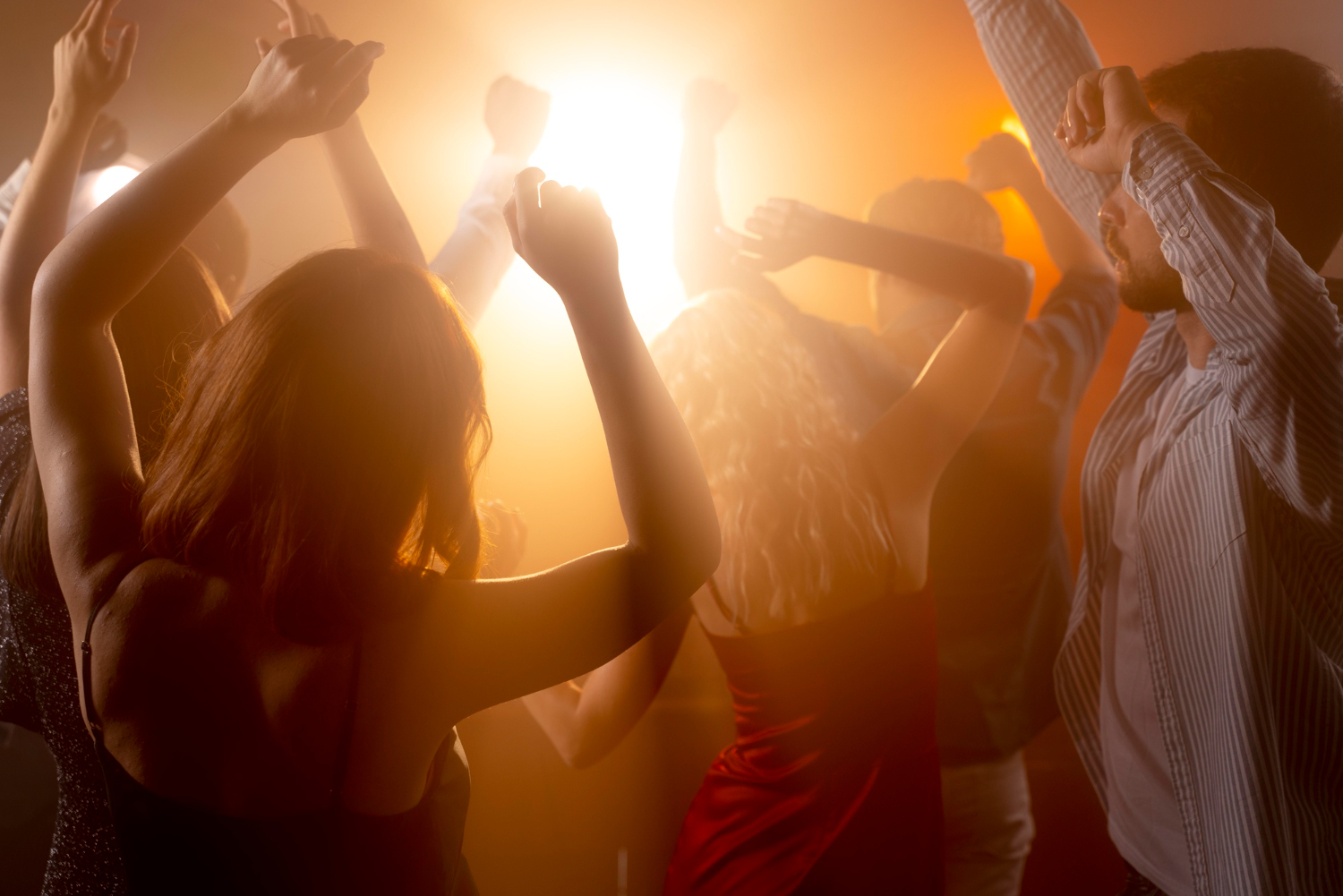 close up of people at nightclub having fun dancing together