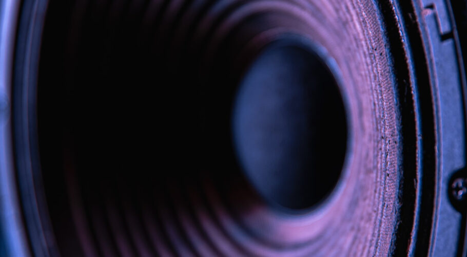 close up speaker membrane black background with colored lighting