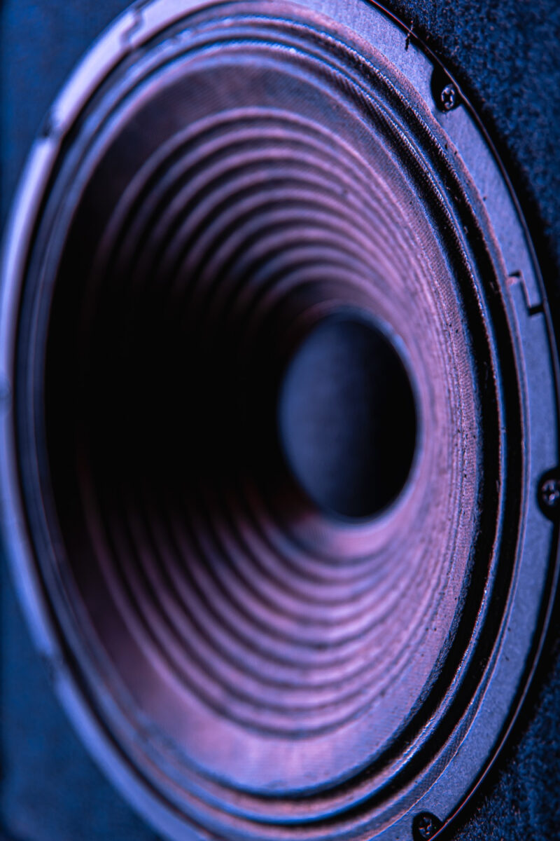 close up speaker membrane black background with colored lighting