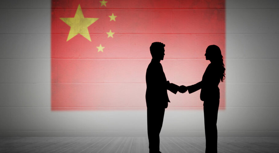 composite image silhouette business people shaking hands between china and western counterparts