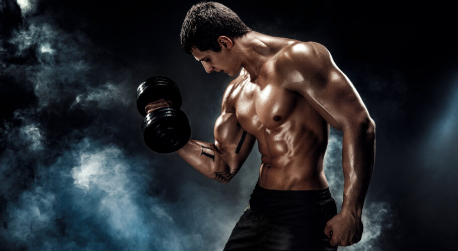 concentrated muscular man doing exercise with dumbbell ripped posing