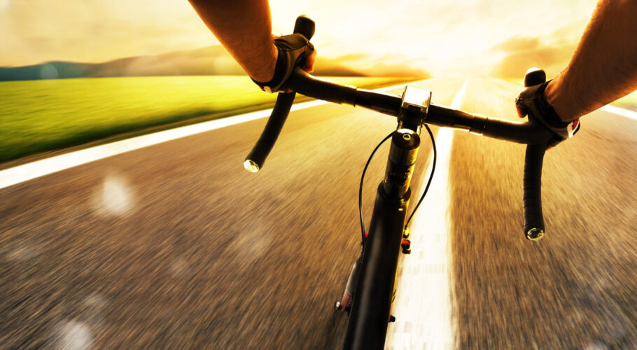 cyclist pedaling fast on a public road in broad daylight