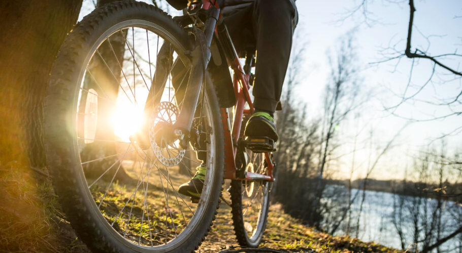 cyclist resting after ride along banks river evening setting sun