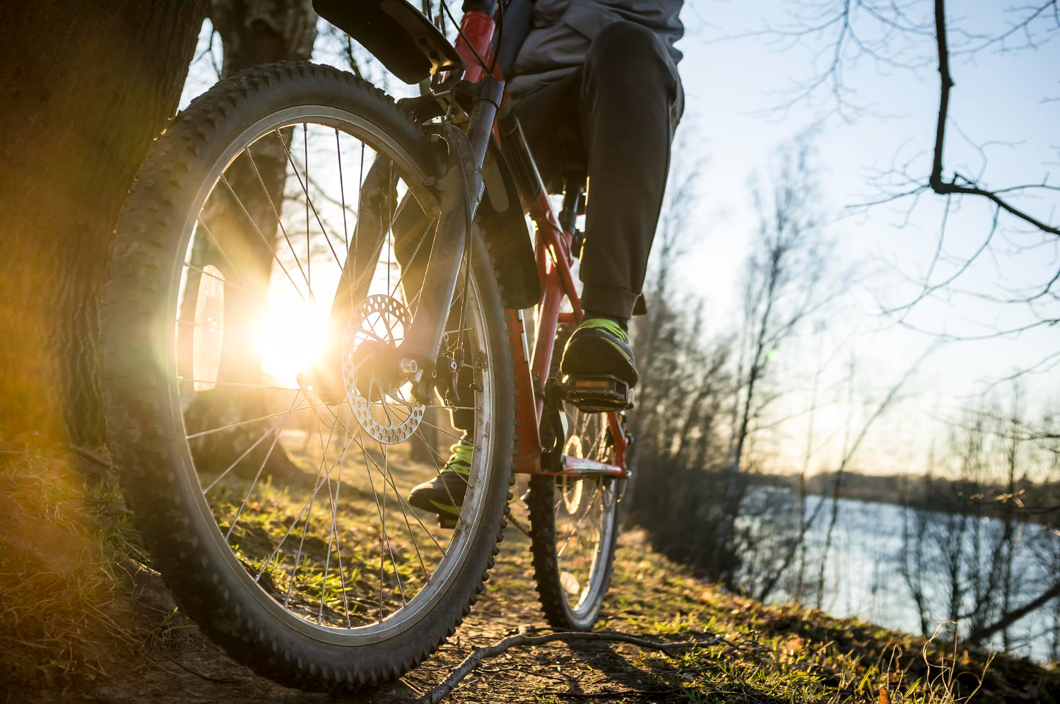 cyclist resting after ride along banks river evening setting sun