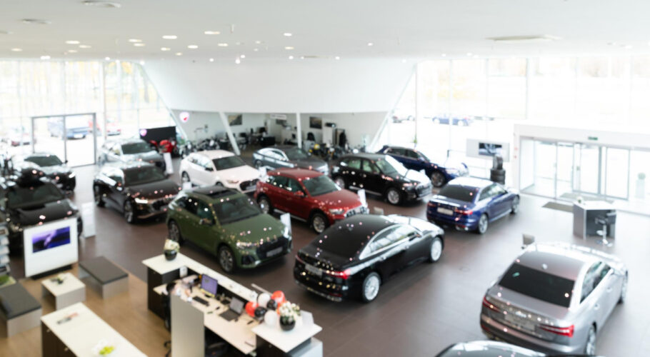 car dealership showroom with premium cars panorama with blur