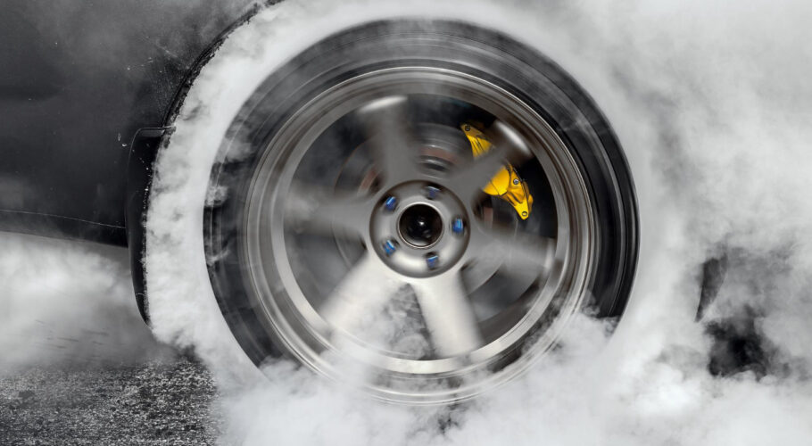 drag racing car burns rubber off its tires preparation race