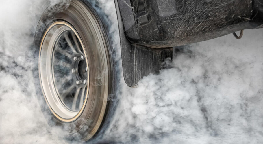 drag racing car burns rubber off its tires preparation race