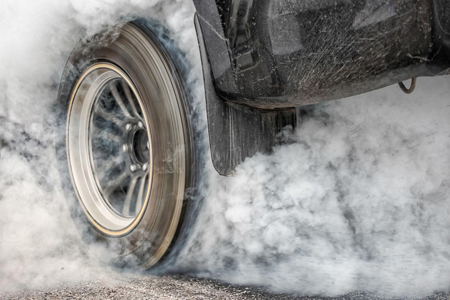 drag racing car burns rubber off its tires preparation race