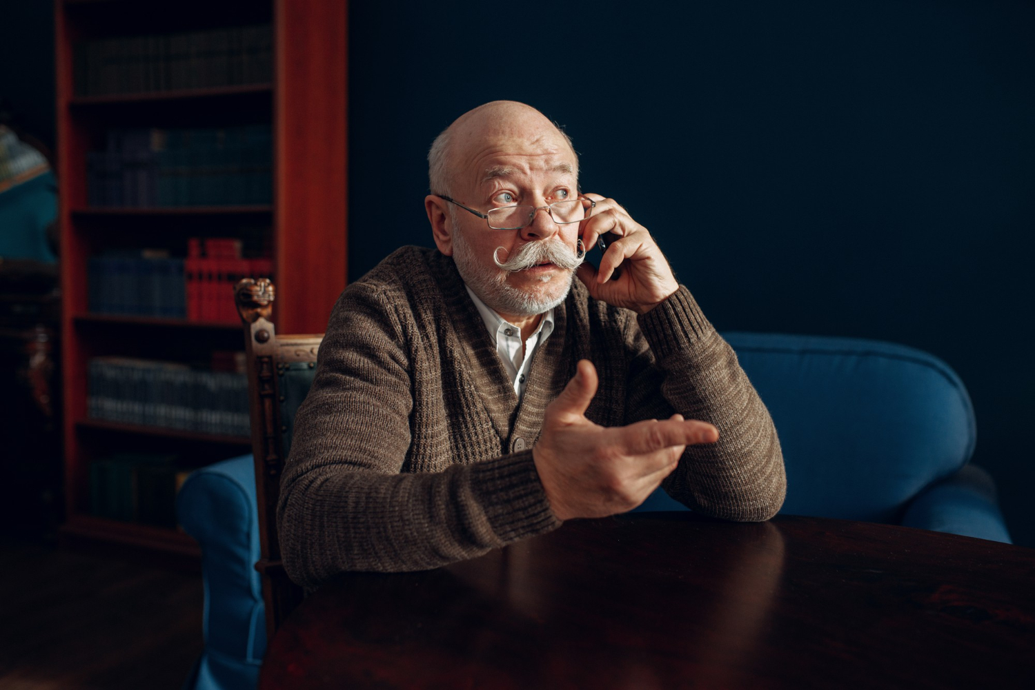 elderly man talking by mobile phone home office
