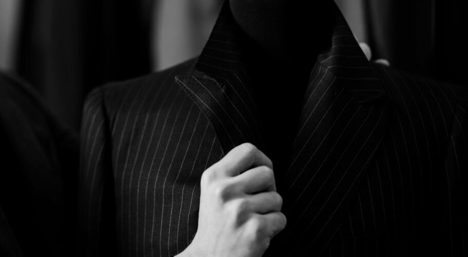 elegant mens suit buyer holds costume collar