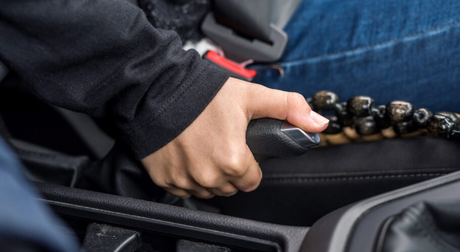 hand holding handbrake lever inside car