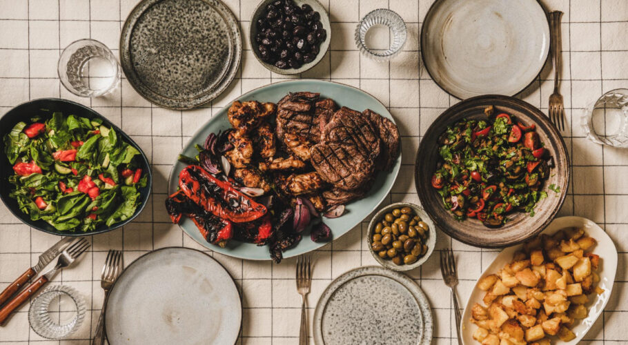 flatlay table with grilled meat chicken vegetables salads potato