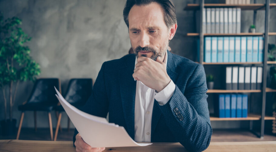 focused busy man qualified expert reading resume CV thinking deciding on candidate hr manager