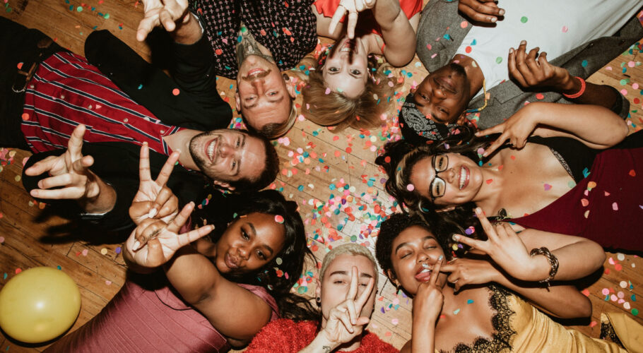 friends lying on the floor at a house party with balloons and drinks