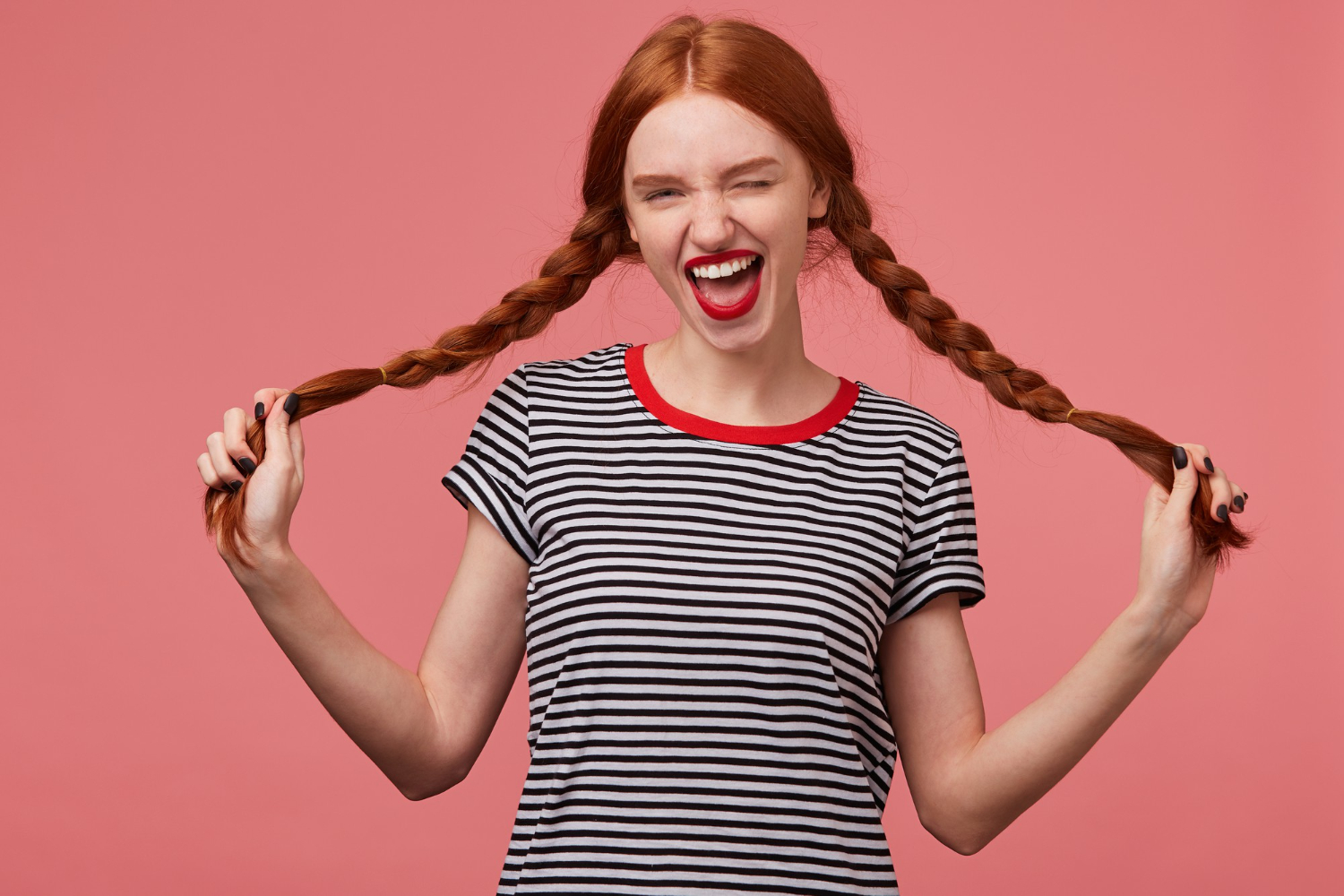 funny joyful girl holding two red haired braids kathryn hands with red lips dressed stripped tshirt dressed