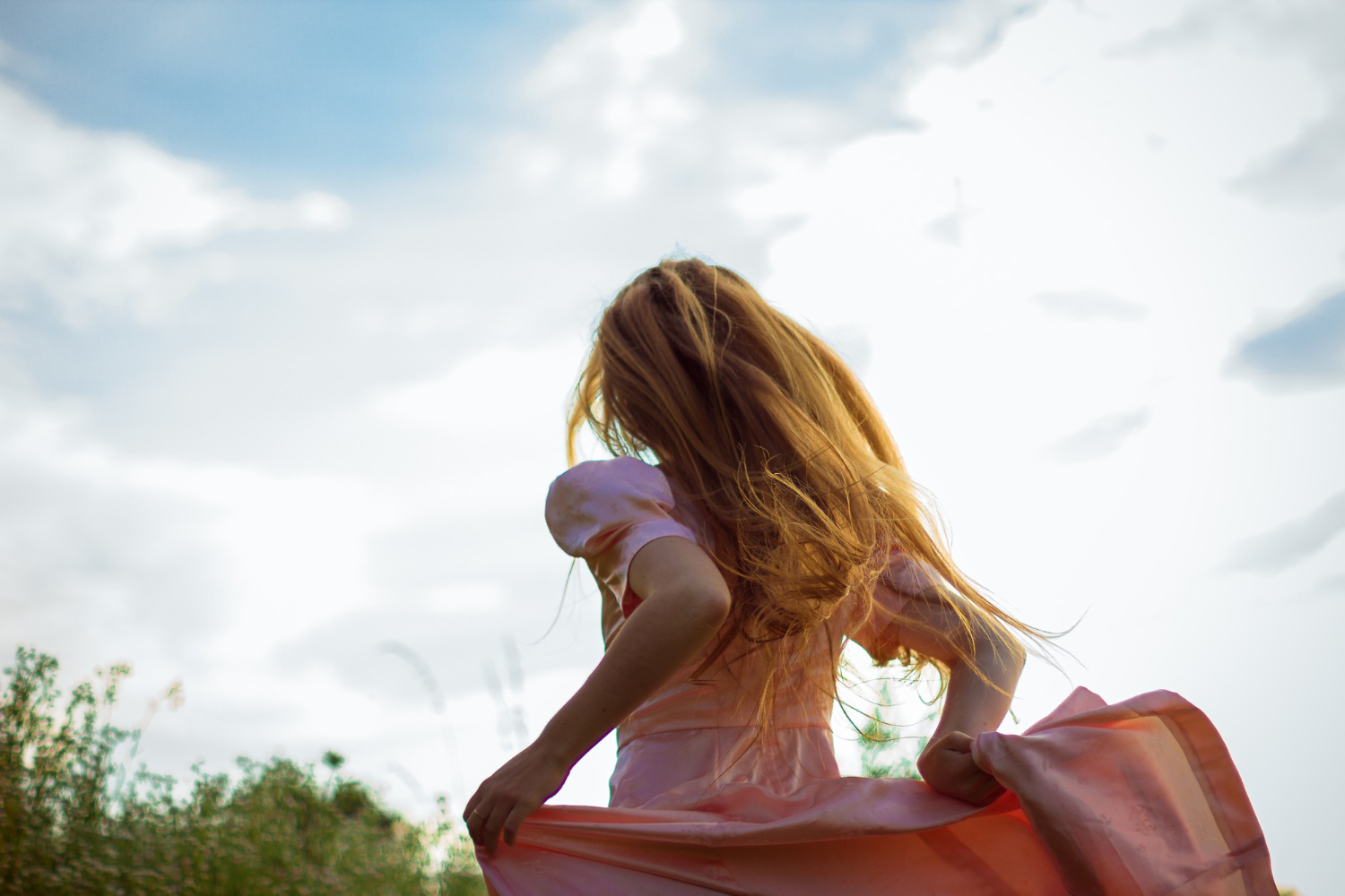girl running across field pink dress