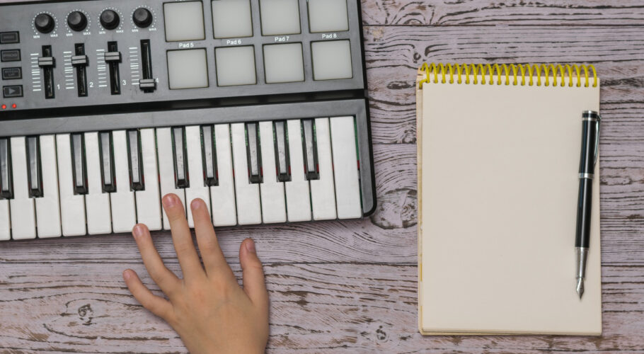 hand music mixer notebook with pen wooden table