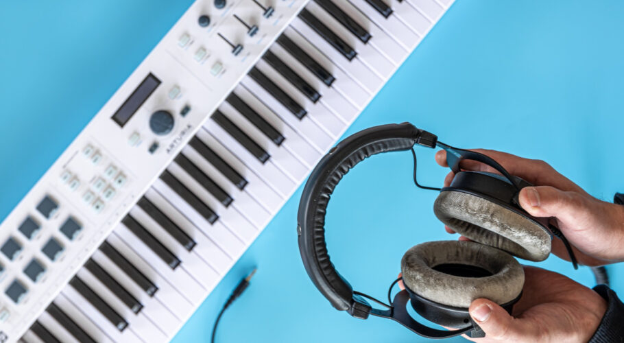 headphones male hands against background musical keys top view