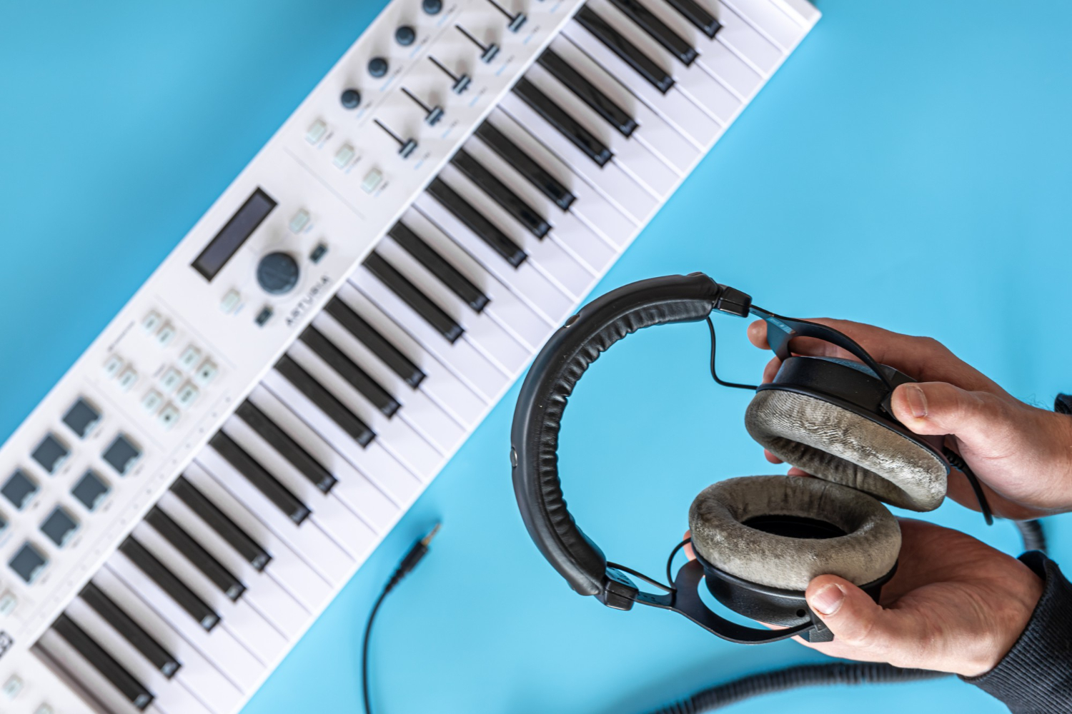 headphones male hands against background musical keys top view