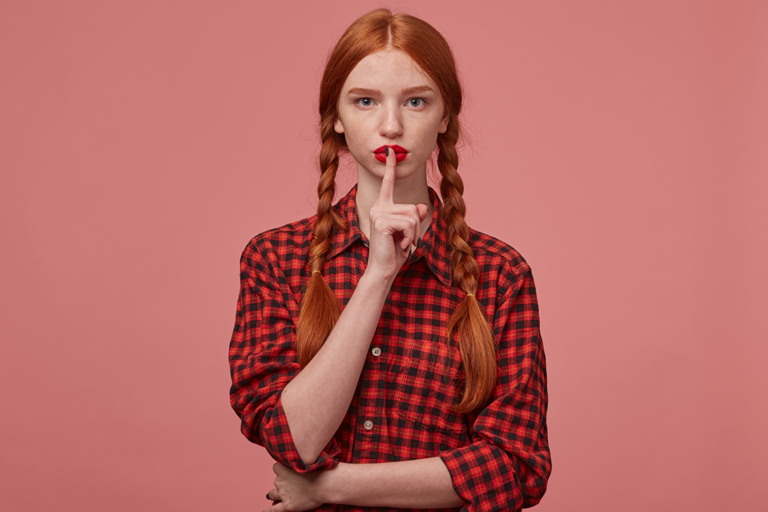 indoor shot serious ginger female showing silence gesture kathryn