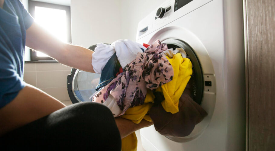 man loading washer dryer with clothes