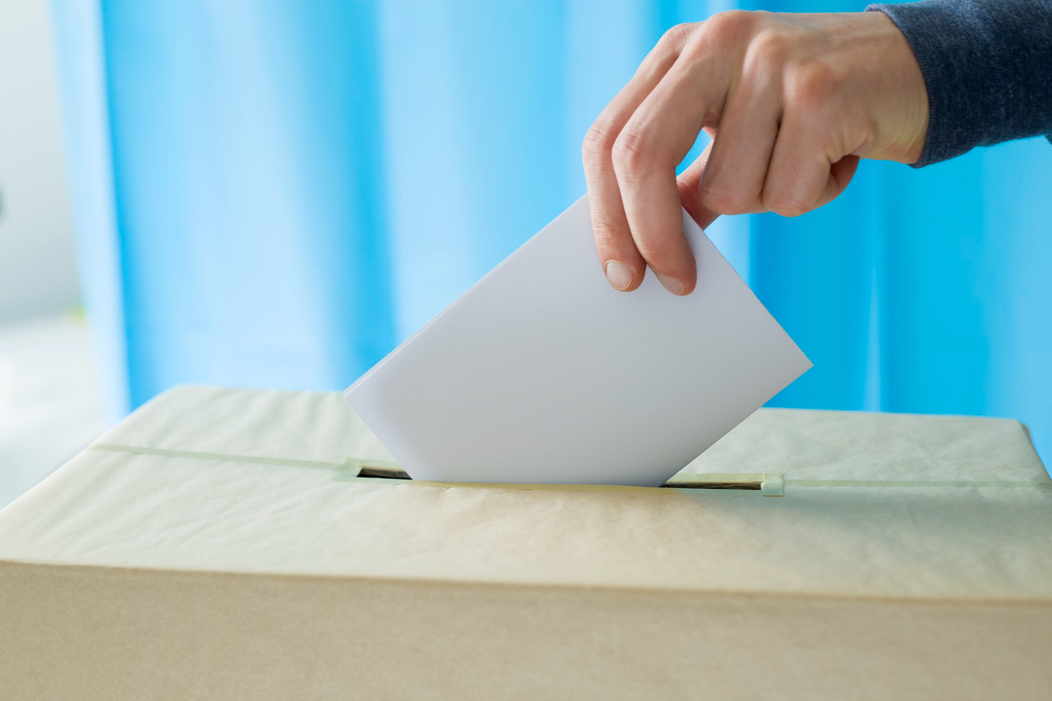 hand throws ballot paper voting polling station during elections