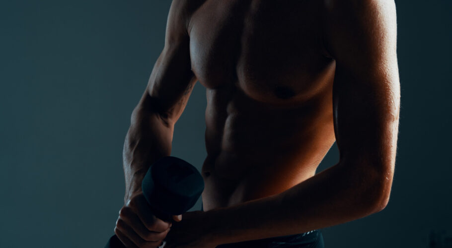 young teenage male with pumped abdominals exercising during workout